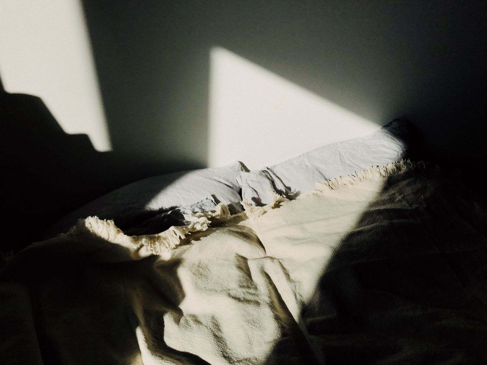 Morning sun falling across rumpled white bedding
