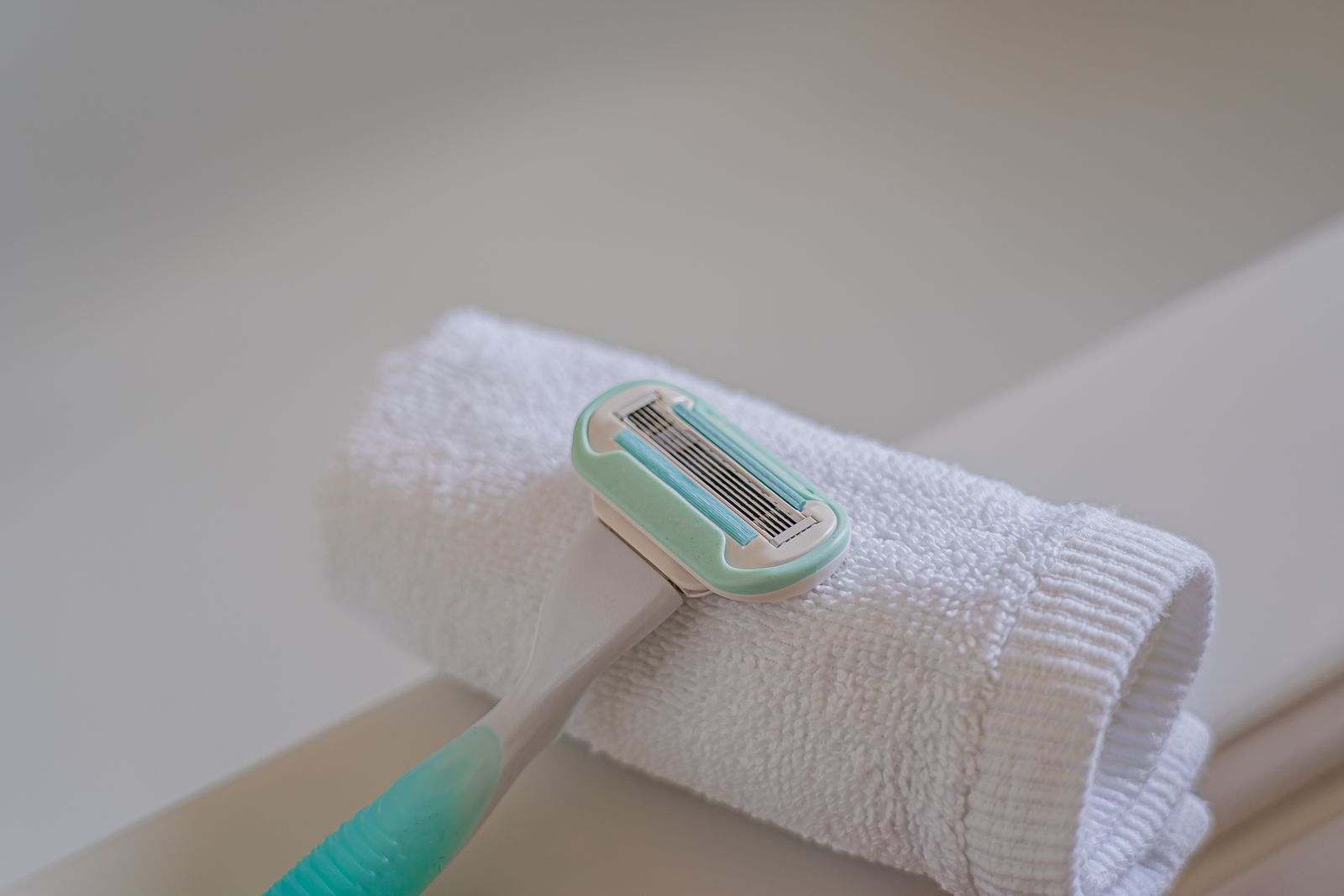 A razor resting on a folded white towel