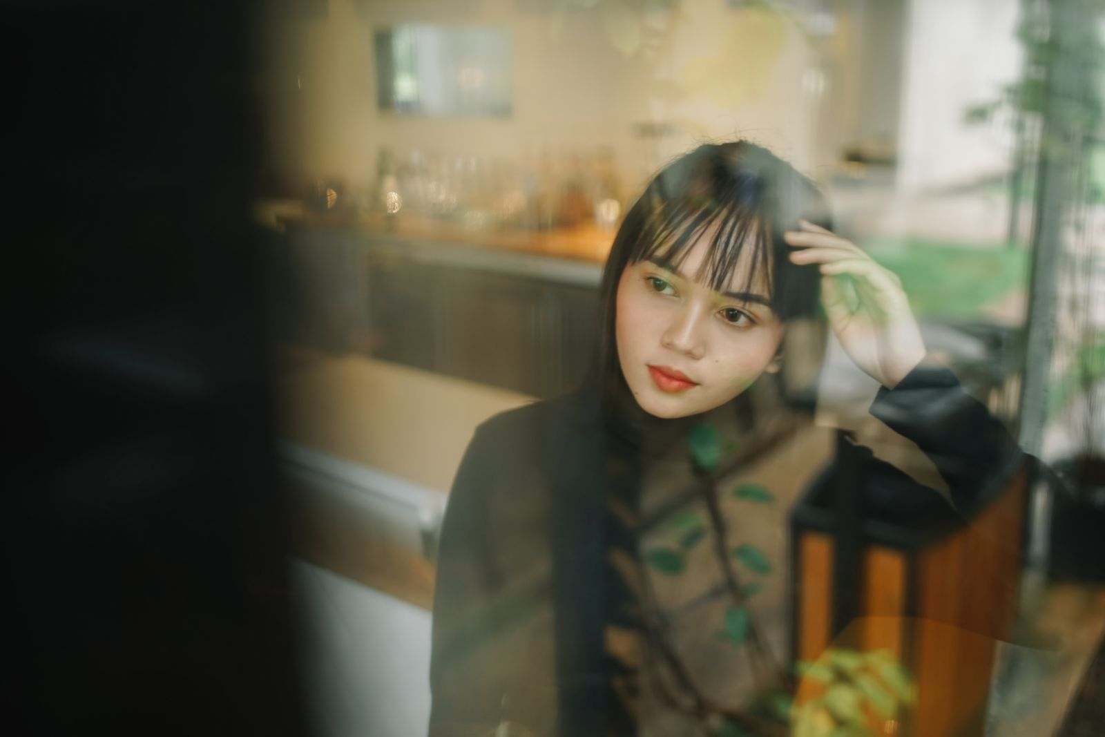 A person looking thoughtful beside a window