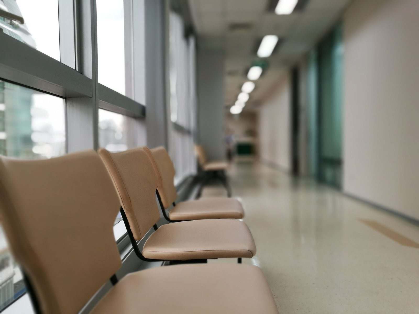 A row of empty chairs in a quiet, softly lit corridor